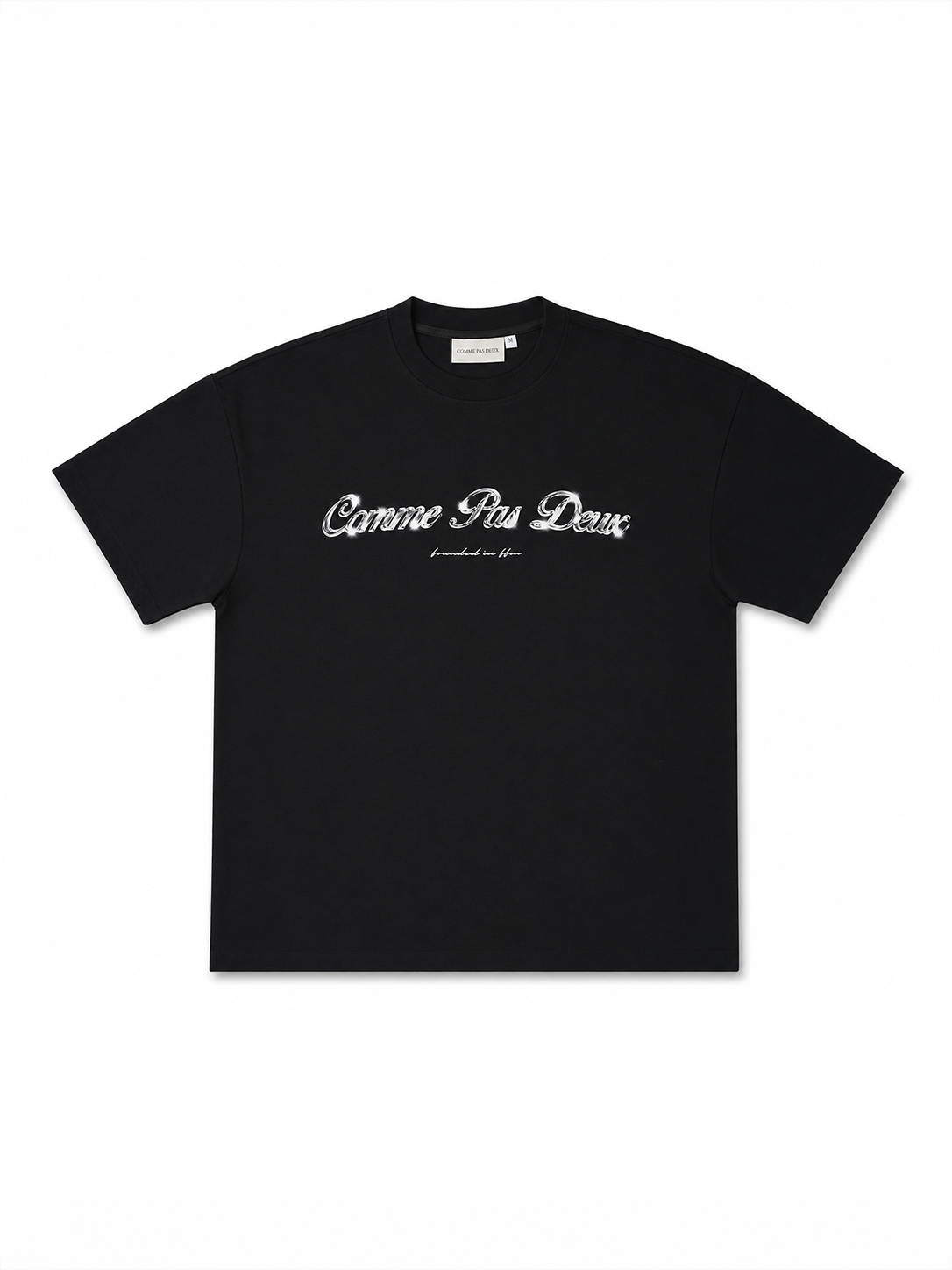 Schwarzes, gekürztes T-Shirt von COMME PAS DE DEUX im Chrom-Design mit lockerer Passform, auf einem weißen Hintergrund.