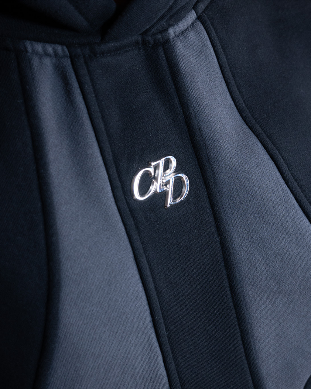 Schwarzer COMME PAS DEUX Hoodie aus weichem Stoff, Nahaufnahme des Kapuzenbereichs und hochwertiger Verarbeitung